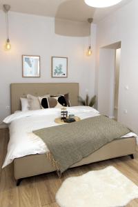 a bedroom with a large white bed and a table at Wanderer Center in Debrecen