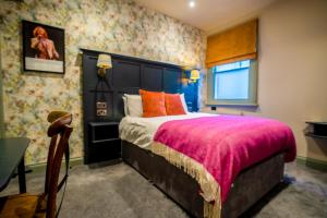 a bedroom with a large bed with a pink blanket at The Crown Hotel in Glastonbury