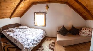 a bedroom with a bed and a couch at Cabana Rustic in Borşa