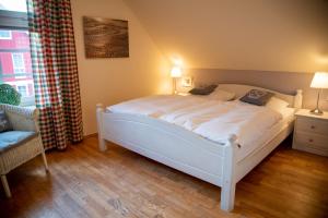 a white bed in a room with a window at Hafenromantik Greetsiel in Krummhörn