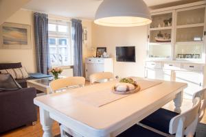 a kitchen and living room with a table and chairs at Hafenromantik Greetsiel in Krummhörn