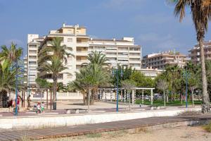 een park met palmbomen voor een groot gebouw bij I-Apartamento cerca de la Playa in Peñíscola