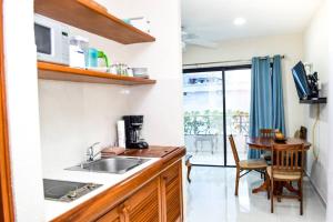 uma pequena cozinha com um lavatório e uma mesa em cancun marlin 32 em Cancún