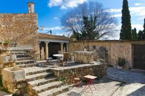 Casa de piedra con escaleras, mesa y sillas en Casa histórica ciclismo, piscina, sauna y jacuzzi, en Lloseta