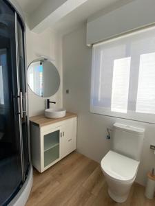 Un baño con inodoro, lavabo y espejo. en San Juan Beach, White House, en El Campello 15 fotos más