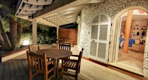 Un patio con una mesa y sillas en una terraza. en Villa Le Lagon - Vision Luxe, en Bonifacio 26 fotos más