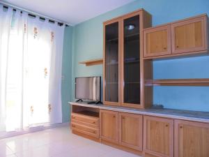 eine Küche mit Holzschränken und einem TV in der Unterkunft Europeñiscola Holidays LEK in Benicarló
