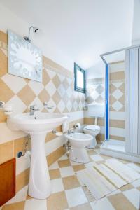 a bathroom with a sink and two toilets at Paradise Beach camera mansardata vicino Cefalù PISCINA APERTA in Campofelice di Roccella