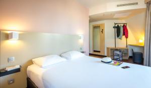 sypialnia z dużym białym łóżkiem z kapeluszem w obiekcie B&B HOTEL Marseille Centre La Timone w Marsylii
