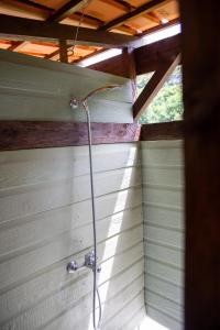 a shower with a hose hanging from a wall at pipowagen Blagour midden in de natuur in Lachapelle-Auzac +20 photos