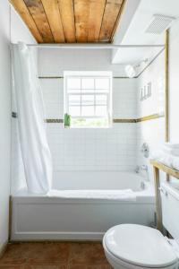 ユクルーレットにあるFern Gully, Coastal Bohemian Loft at Beachのバスルーム(白いバスタブ、トイレ付)