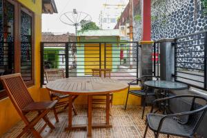 - Balcón con mesa y sillas de madera en KoolKost Syariah near Malioboro Area, en Yogyakarta
