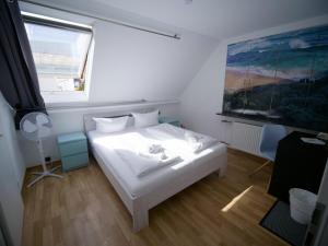 a bedroom with a white bed and a window at Gästehaus Parkblick in Rust