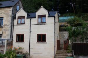 una casa blanca con techo negro en Penrith Lodge, en Stroud
