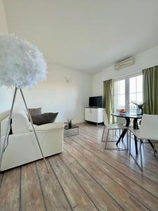 a living room with a white couch and a table at Apartment STAR Blažev in Primošten