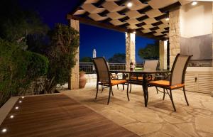 a patio with a table and chairs on a deck at 3 bedroom Villa Madelini with private pool, Aphrodite Hills Resort in Kouklia