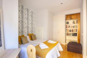 a small bedroom with a bed and a book shelf at Heima Retiro Park-Ibiza in Madrid