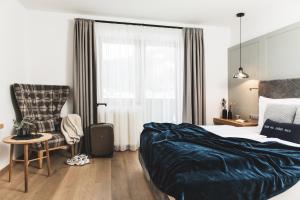 Postel nebo postele na pokoji v ubytování Alpines Gourmet Hotel Montanara