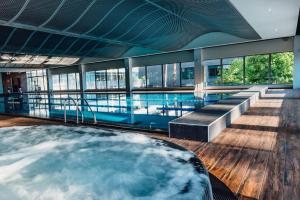 a hot tub in the middle of a building with a pool at Lielupe Hotel SPA & Conferences by Semarah in Jūrmala