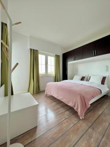 a bedroom with a large bed and a wooden floor at Apartment STAR Blažev in Primošten