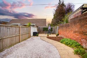 a backyard with a fence and a brick wall at The Pink House Canterbury FREE Parking WIFI in Canterbury