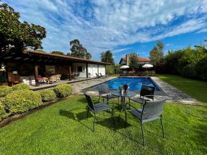 a table and chairs in the grass next to a pool at La Casa de Somio in Gijón