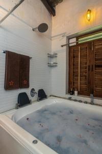 a bath tub with two chairs in a bathroom at SaffronStays Ambaram, Pali in Māngaon +23 photos