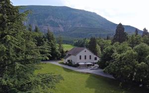 une vue aérienne sur une maison avec une montagne en arrière-plan dans l'établissement La Source, à Saint-Pierre-dʼArgençon