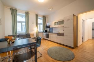 ein Wohnzimmer mit einem Sofa und einer Küche in der Unterkunft Konrad I levestate in Wien