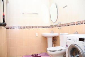 y baño con lavabo y lavadora. en BEST GUESTHOUSE, en Tashkent