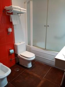 e bagno con servizi igienici, doccia e lavandino. di Apartamentos Astilleros a Candás