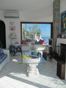 uma sala de estar com uma mesa de vidro em frente a uma janela em Relais Bijoux Ischia em Ischia