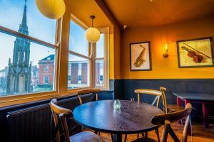 a dining room with a table and chairs and a large window at The Crown Hotel in Glastonbury