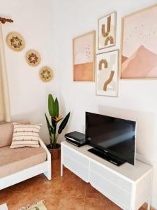 a living room with a flat screen tv on a white table at Villas El Pinar in Cala en Blanes