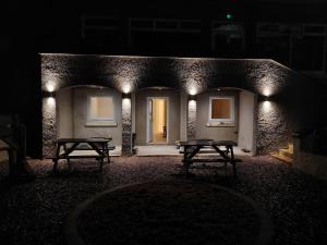 クリクキエスにあるThe Coveの夜の建物の前にあるベンチが2つある部屋