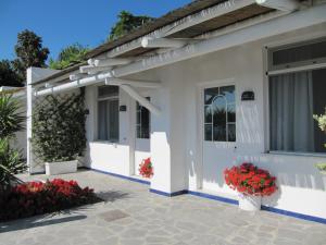 a white house with flowers in front of it at Relais Bijoux Ischia in Ischia