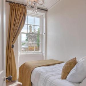 a bedroom with a bed and a window at Goshen Cottage in Kelso