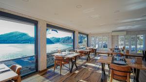 a restaurant with tables and chairs and large windows at Dolphin Boutique Hotel & Restaurant in Karacaören