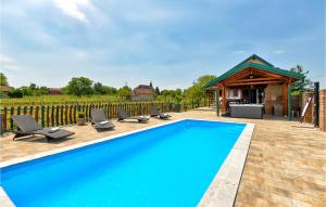 una piscina con sedie a sdraio e un edificio di Gorgeous Home In Prugovac With House A Panoramic View a Prugovac