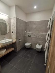 a bathroom with two toilets and a sink and a mirror at Sareza hotel in Ostrava