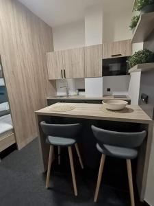 a kitchen with a counter with two chairs and a counter top at Sareza hotel in Ostrava
