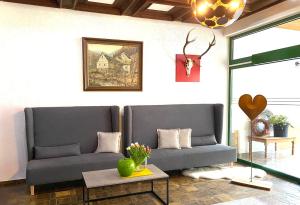 ein Wohnzimmer mit 2 Sofas und einem Tisch in der Unterkunft Hotel Ostermann in Treis-Karden