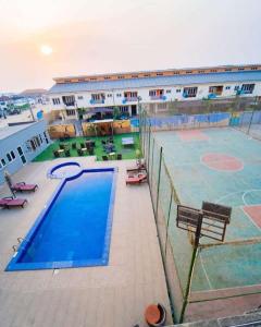 una grande piscina con campo da basket di fronte a un edificio di BOL LODGE AND APARTMENT a Lagos