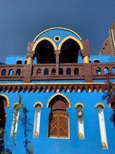 ein blaues Gebäude mit brauner Tür und Fenstern in der Unterkunft Golden Palace Garden in Luxor