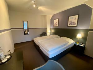 um quarto de hotel com uma cama e uma mesa em Hotel Kaiserswerth em Dusseldorf