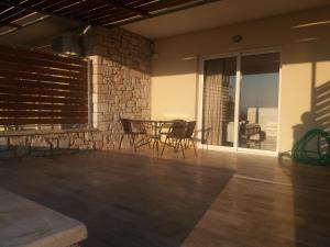 un patio con mesa, sillas y mesa en Nereids Apartments-Galene, en Petalidi