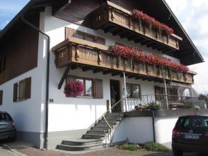 a building with a balcony with flowers on it at Gästehaus Bach in Oberstdorf