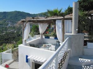 a balcony of a house with a table and chairs at Relais Bijoux Ischia in Ischia