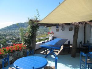 a blue table and chairs on a patio with flowers at Relais Bijoux Ischia in Ischia