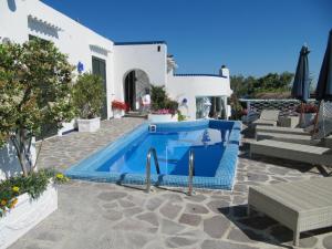 a swimming pool in front of a white house at Relais Bijoux Ischia in Ischia
